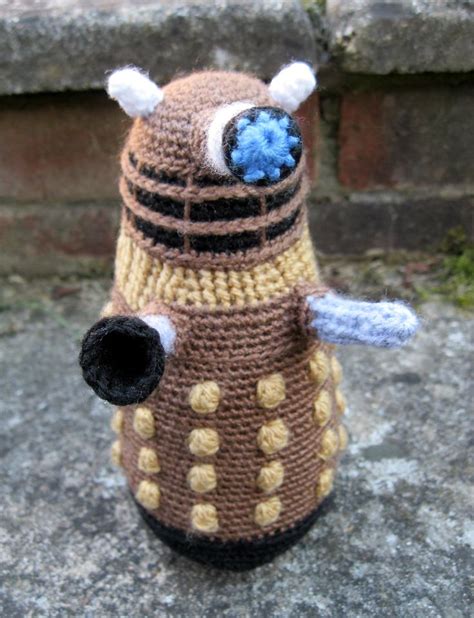 A Crocheted Dalen From Doctor Who Is Sitting On The Ground Next To Some