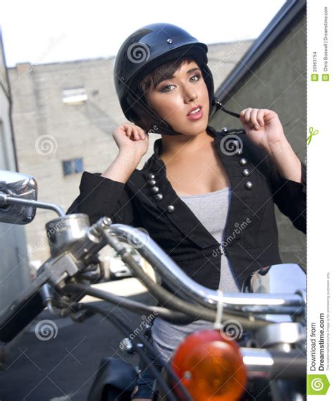 Young Woman On Motorcycle Adjusts Helmet Stock Photo