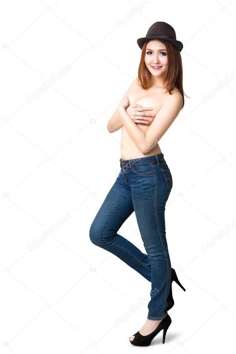 Söpö yläosaton nuori aasialainen tyttö poseeraa sinisissä farkuissa