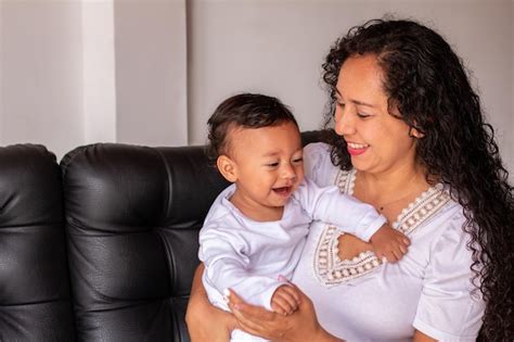 Madre E Hijo Vestidos De Blanco Sentados En Un Sofá Bebé Sonriente Y
