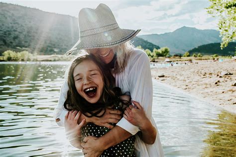 Mom And Daughter Hugging And Laughing While Standing In A Lake