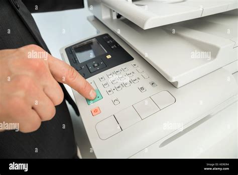 Close Up Of Businessman Hand Pressing Printers Button In Office Stock