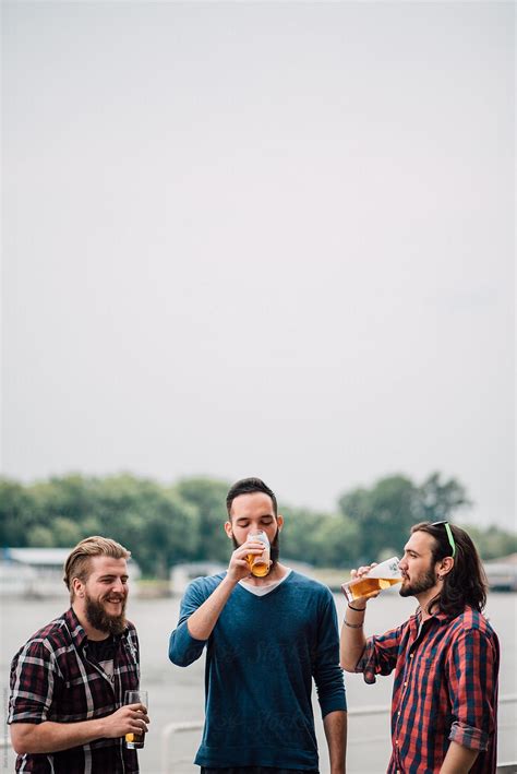 Friends Drinking Beer Outdoors By Stocksy Contributor Boris