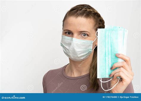 Woman In A Protective Medical Mask Holds In Her Hands A Protective