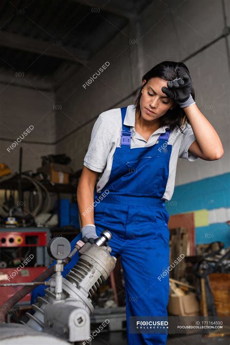 Tired female mechanic fixing compressor engine with wrench — service ...