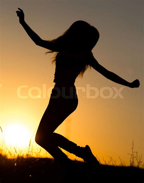 Silhouette Of A Girl Jumping Up At Sunset Stock Image Colourbox