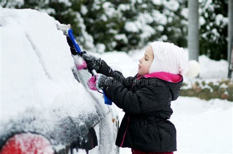 Child Brushing Snow Off Carkid With Winter Brush And Scraper Clearing