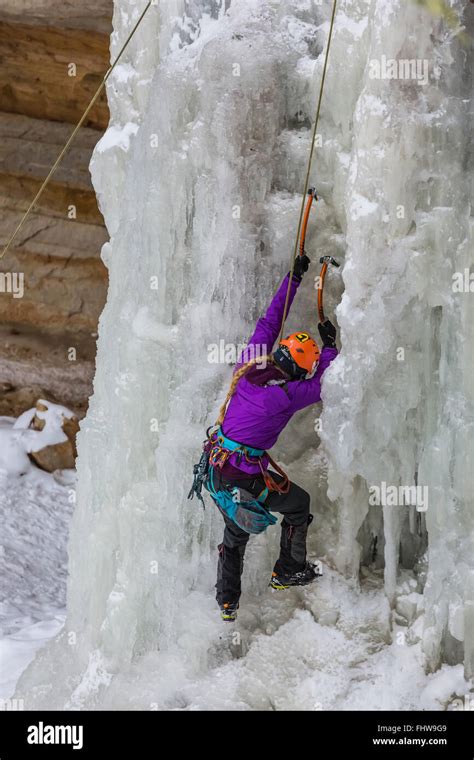 Woman Ice Climber Ascending A Frozen Waterfall In Pictured Rocks