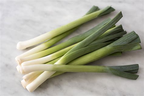 Several Fresh Green Leeks On A Marble Bench Top Free Stock Image