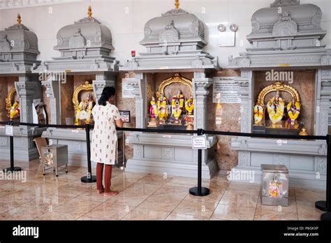 A Woman Praying And Meditating At The Hindu Temple Society In Flushing