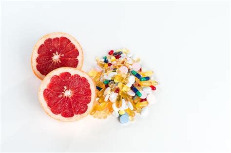 Grapefruit And Pills Vitamin Supplements On White Background Healthy