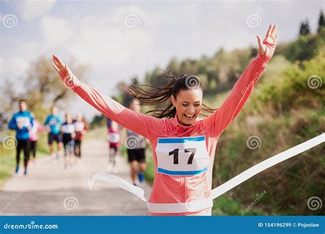Young Woman Runner Crossing Finish Line In A Race Competition In Nature