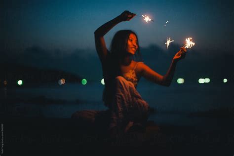Beautiful Young Woman Dancing By The Sea With Sparkler In Summer Night