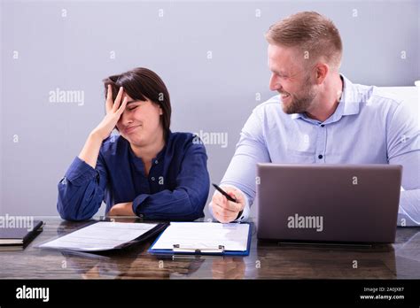 Woman Sitting New Annoying Male Colleague Telling Another Lame Joke At Work In Office Stock