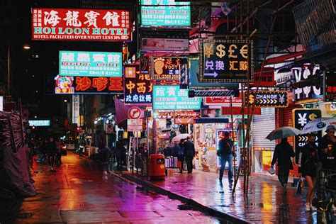 Hong Kong Street At Night With Neon Signs And Lights Reflecting Off Of