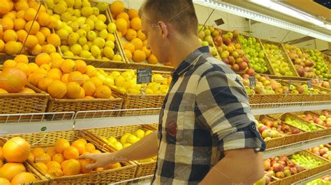 Man Selecting Fresh Fruits In Grocery Store Produce Department And