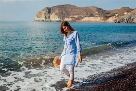 Tourist Woman Walking On Coastline Of Red Beach Santorini Island Greece