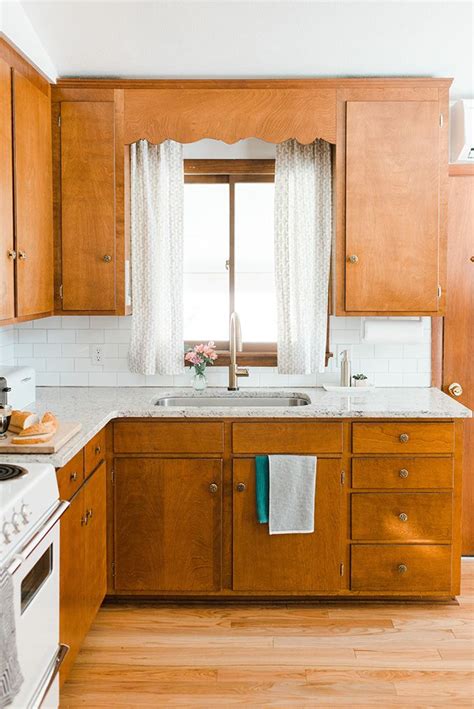 A Kitchen With Wooden Cabinets And White Counter Tops Along With A