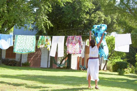 Caucasian Woman Hanging Laundry On Clothes Line Stock Photo Dissolve