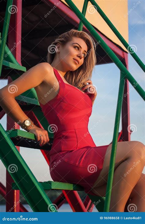 Piękna Blondynka W Seksownej Czerwieni Sukni Siedzi Na Krokach Zdjęcie Stock Obraz Złożonej Z