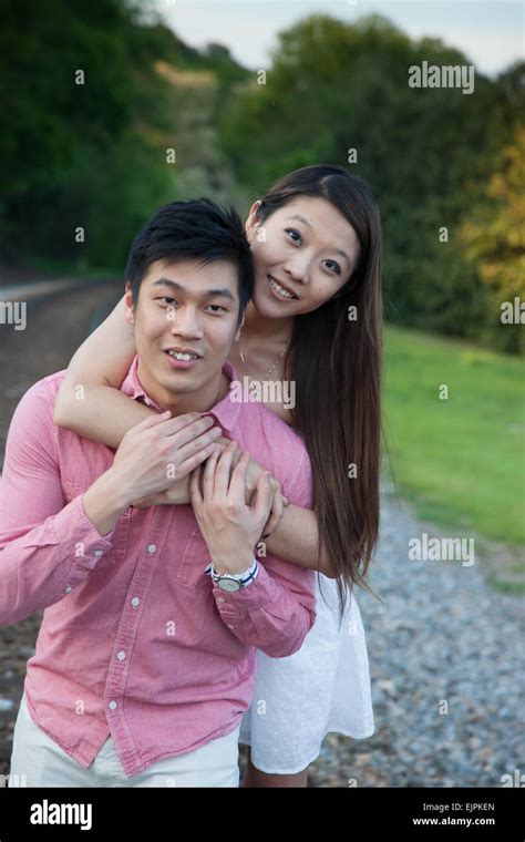 Romantic Asian Couple Playing Outside Being Affectionate And Smiling