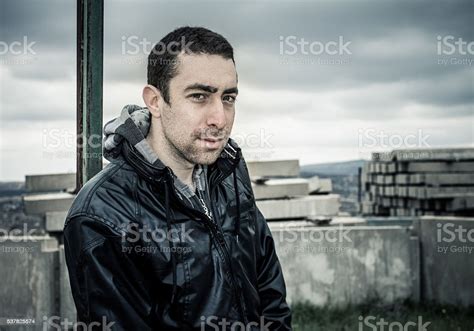 Man Looking At Camera With Sly Smile On Serious Face Stock Photo