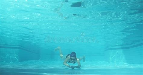 Athletic Teenager Girl Swimmer Underwater In Blue Outdoor Pool Looking