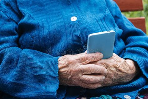Senior Mature Woman Grandmother Holding Phone Using Mobile Device Apps Looking At Screen