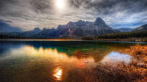Gray Mountains And Calm Body Of Water Near Mountain During Daytime With