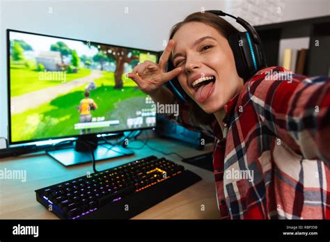 Excited Girl Gamer Sitting At The Table Playing Online Games On A