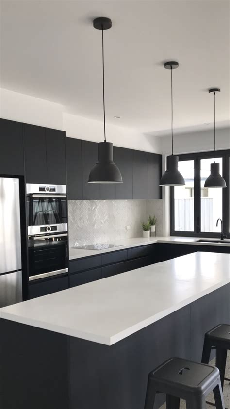 Modern white and brass light fixtures complete the look. Black and white kitchen, Bosch appliances, absolute matte ...