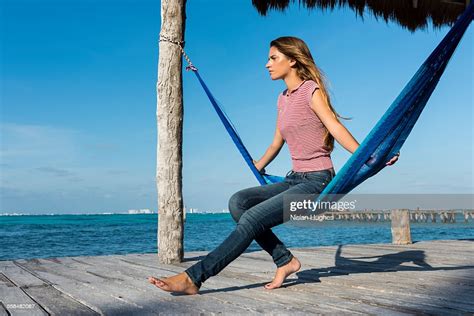 Woman Sitting In Hammock Looking Out Over Ocean Photo Getty Images