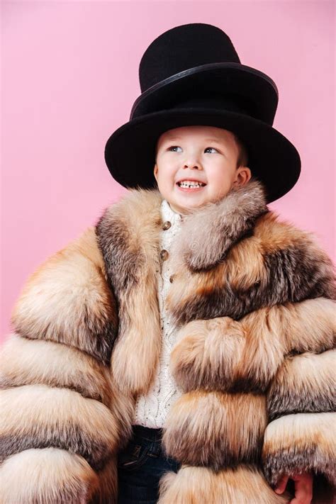 Funny Grinning Little Boy In Fur Coat He Has Put Two Classical Hats On