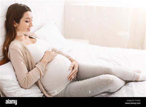 Happy Pregnant Lady Caressing Her Belly Lying In Bed Stock Photo Alamy
