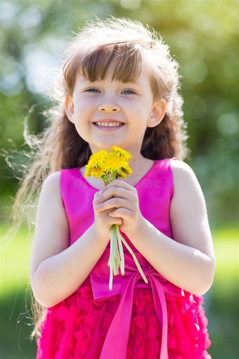 A Little Girl Is Holding A Bouquet Of Flowers Stock Photo Image Of