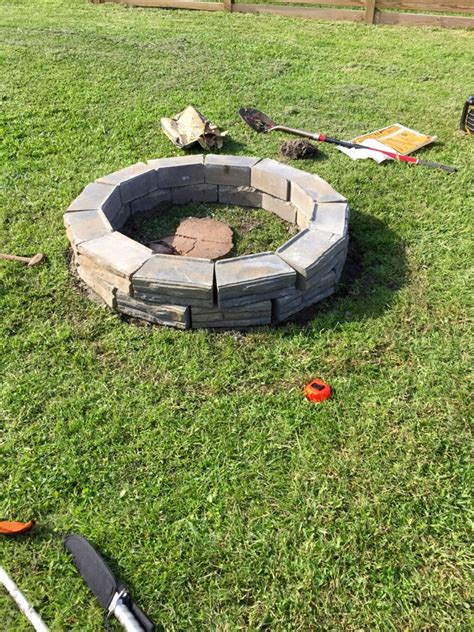 Here's how i made my fire pit out of regular retaining wall blocks/bricks and a galvanised round garden bed for the central steel rim. Remodelaholic | DIY Retaining Wall Block Fire Pit