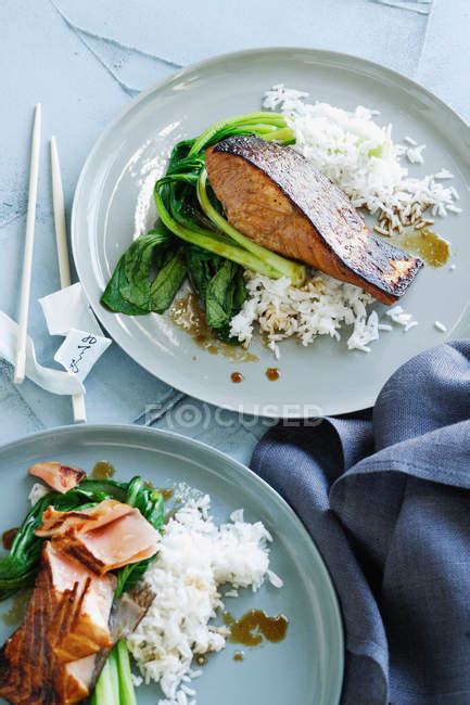 Plates Of Fish Rice And Greens — Vertical Cuisine Stock Photo