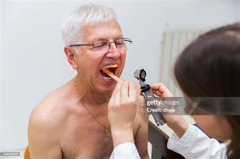 Young Woman Doctor Checking Patients Oral Cavity With Otoscope High Res