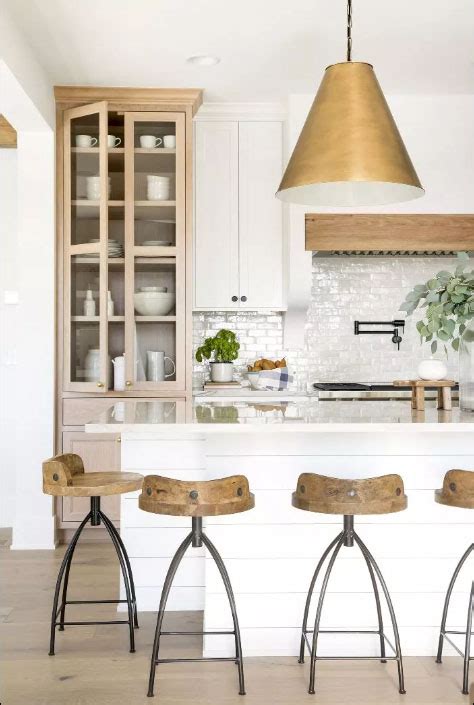 The cabinets sit on a black countertop accenting white flat front lower cabinets adorned with antique brass pulls. Countertop Cabinets in the Kitchen - The Honeycomb Home