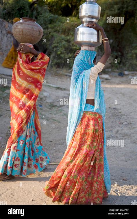 rural women carrying water pots on head semi urban village dilwara udaipur rajasthan