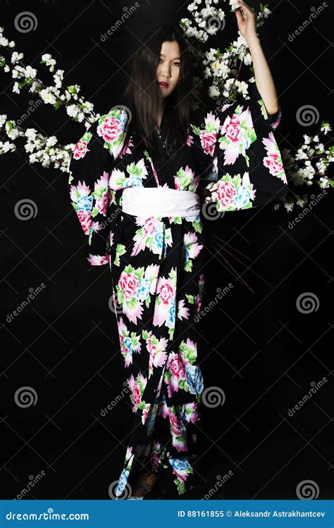 Japanese Girl In Traditional Japanese Kimono Holds Sprigs Of Ch Stock