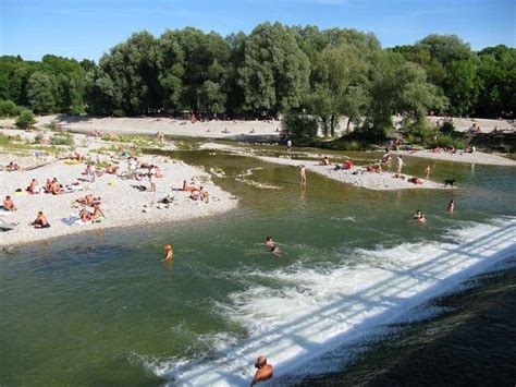 Many People Are Swimming In The River And On The Beach While Others Swim Nearby