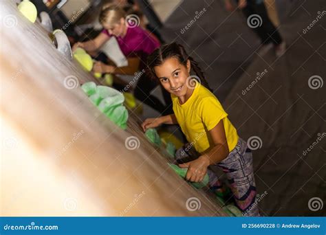 Instructors Helping Children Climb Wall In Gym Stock Photo Image Of