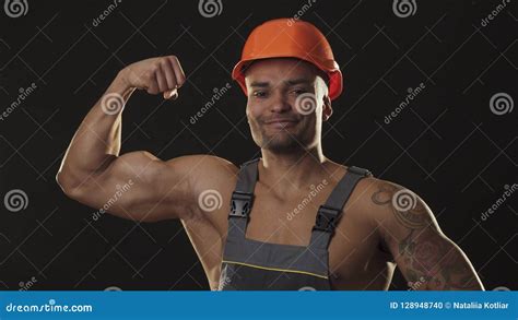 Muscular Ripped African Male Builder In Workwear And Hardhat Flexing
