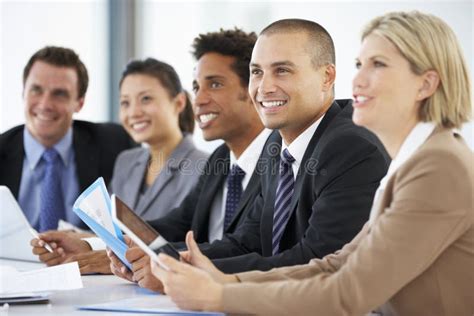 Group Of Business People Listening To Colleague Addressing Office