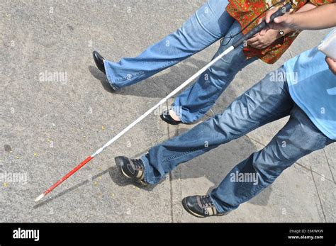 Blind Man With A Blind Walking Cane And A Woman On The Street Stock