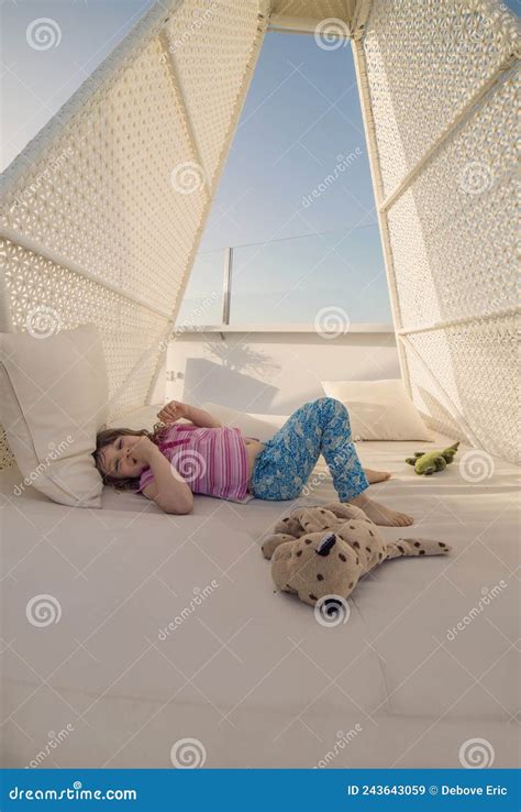 Little Girl Resting In The Shade Of A Patio In The Garden Stock Image