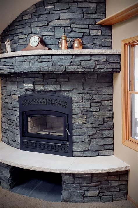 This cast stone electric fireplace features intense carvings and a black fossil stone top. Black Frost Ashlar Veneer Stone Fireplace in 2020 | Stone ...