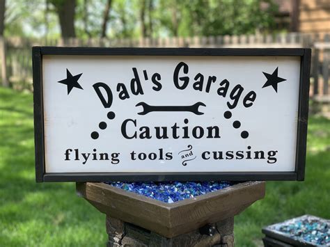 This Fun Wood Sign Reads Dads Garage Caution Flying Tools And Cussing