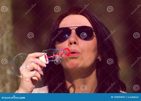 The Young Woman Has Bubble Blower And She Blows Bubbles Stock Image